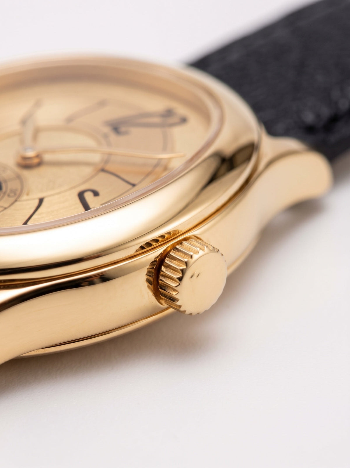 LOUVOND Lucien horloge met gepolijste goudkleurige kast, gouden wijzerplaat en zwarte generfde leren horlogeband.