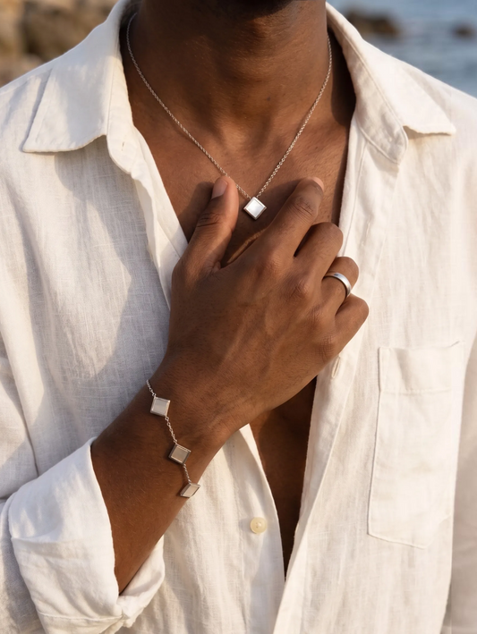 LOUVOND Prisma Link Pendant ketting met vierkante hanger en bijpassende armband in zilverkleur op een model.
