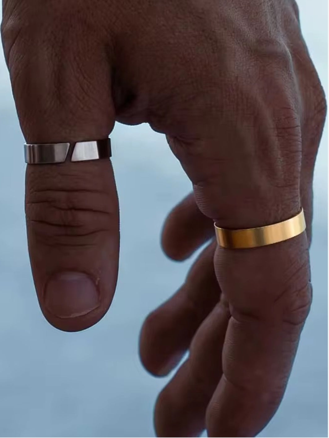 Pair of men’s rings: one gold and one silver, polished finish