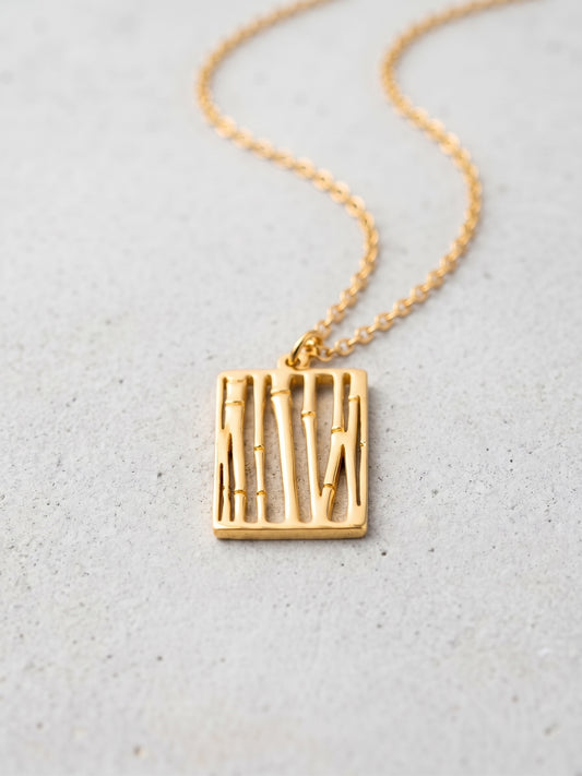 LOUVOND Abstract Pendant met rechthoekige goudkleurige hanger met verticale lijnen aan een fijne ketting.