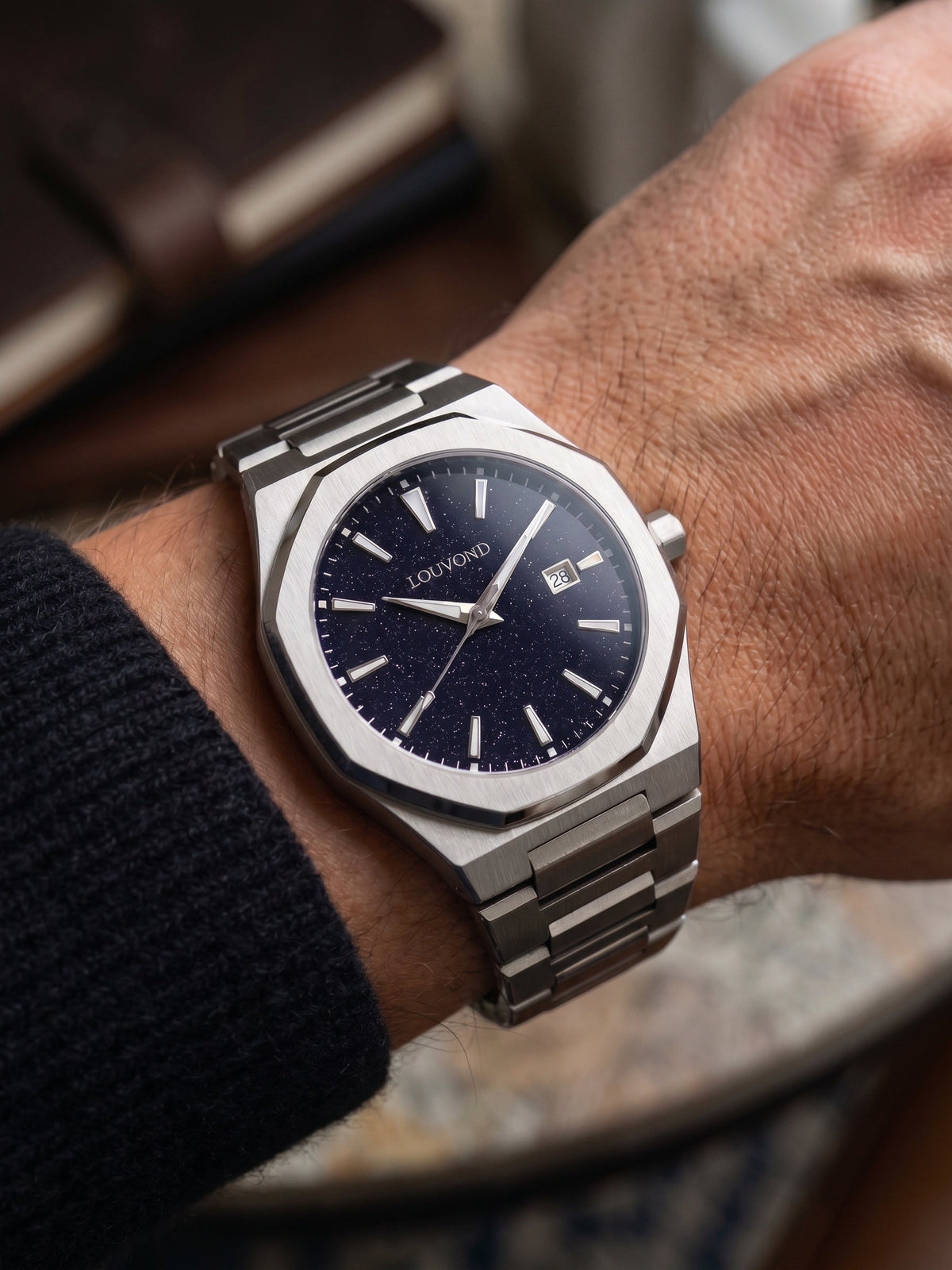 LOUVOND Célestin horloge met een donkerblauwe aventurijn wijzerplaat en een roestvrijstalen horlogeband om de pols.