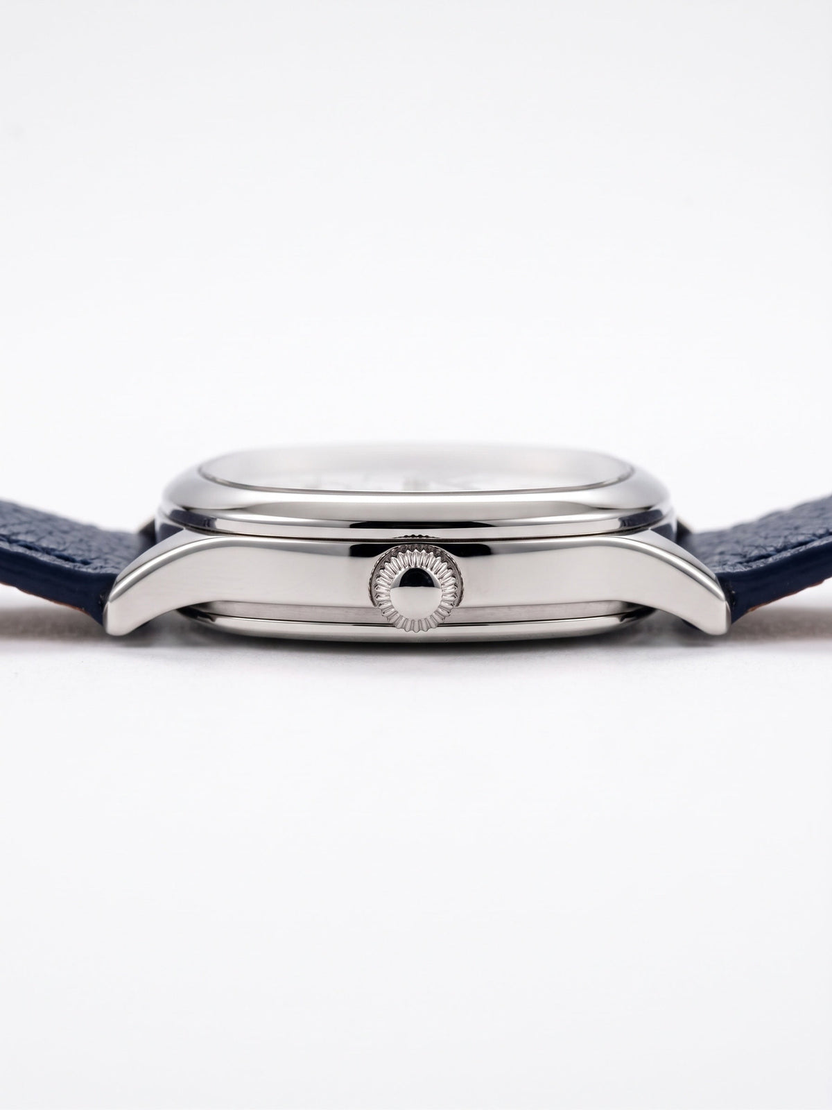 Zijaanzicht van het LOUVOND Lucien horloge met gepolijste zilverkleurige kast en marineblauwe lederen horlogeband.