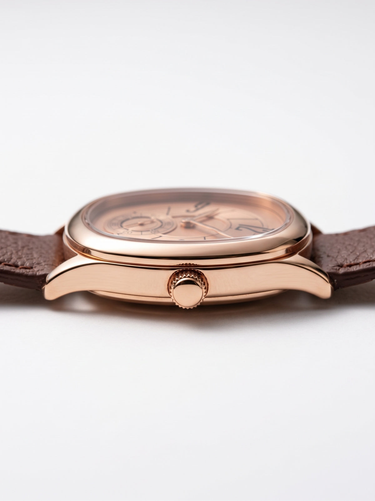 Zijaanzicht van het LOUVOND Lucien horloge met roségouden kast, champagne wijzerplaat en bruine leren horlogeband.