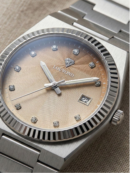 LOUVOND Monarch horloge met goudkleurige wijzerplaat, diamantindexen en geribbelde lunette in een zilveren kast.
