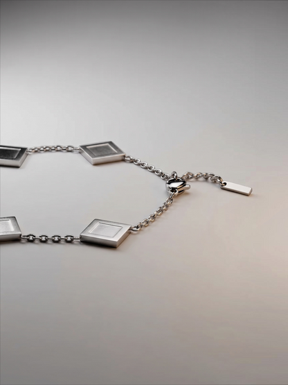 LOUVOND Prisma Link armband in zilverkleur met geometrische vierkante bedels en een verstelbare schakelketting.