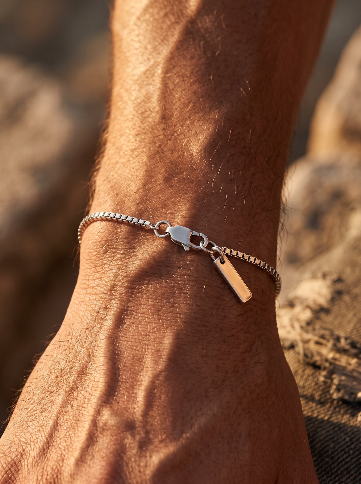 LOUVOND REVO armband met minimalistisch vierkant schakelontwerp in zilverkleur gedragen om een pols.