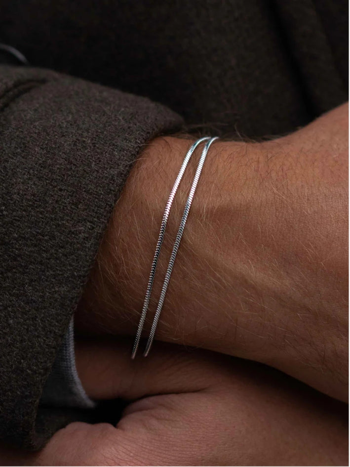 Man wearing minimalist silver bracelet featuring a square link design, lightweight and waterproof.